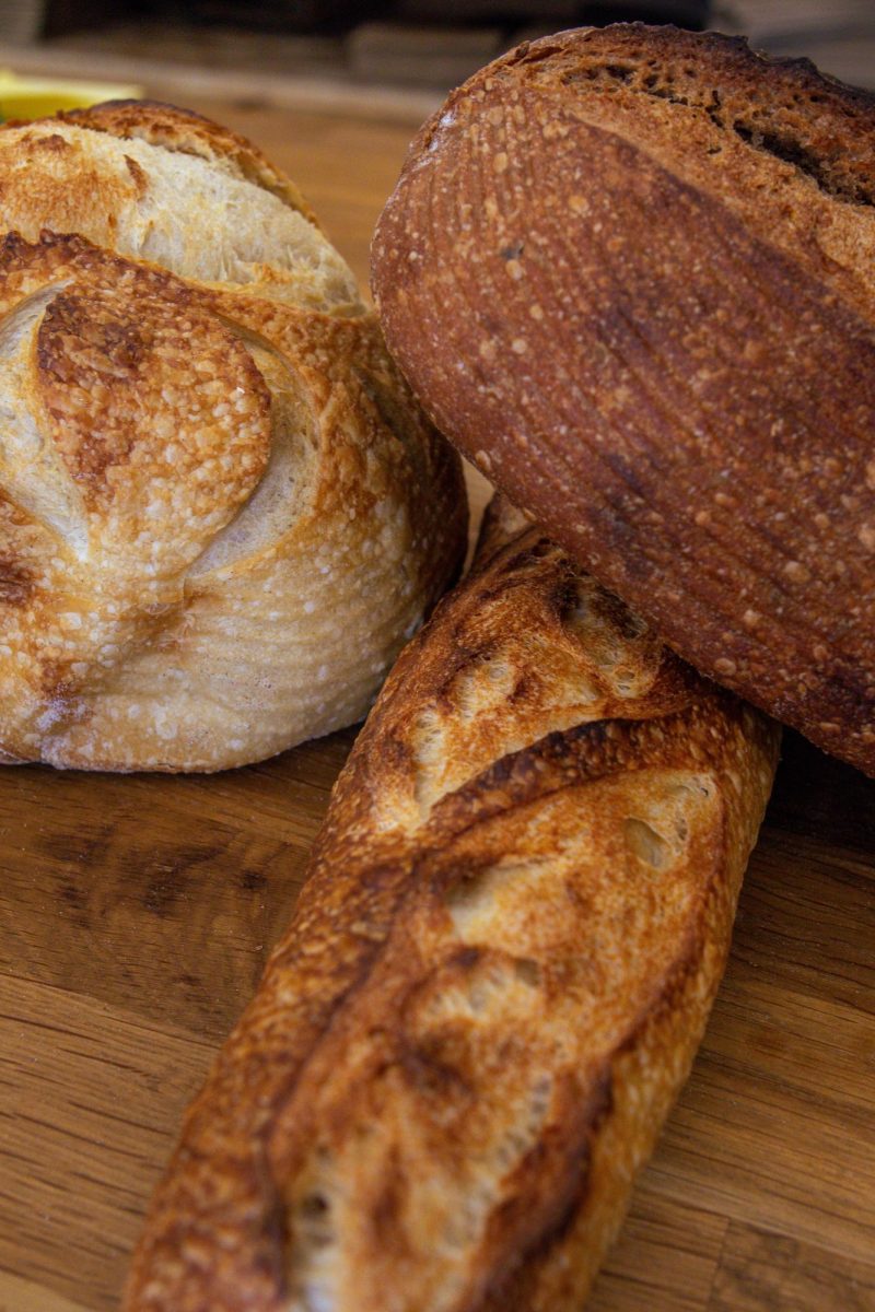 The Bread Chic, a Fort Collins local bakery offers freshly baked pastries and breads Monday through Sunday. A Rye loaf, Rosemary sourdough loaf, and Baguette are shown stacked on top of one another. Apr. 8.