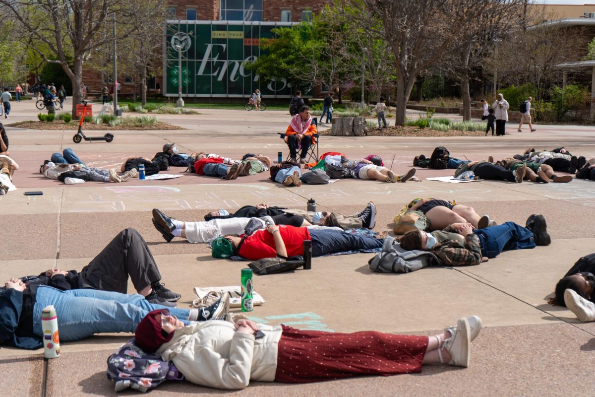 Several protesters lie on the ground of The Plaza with the Morgan Library visible in the background.