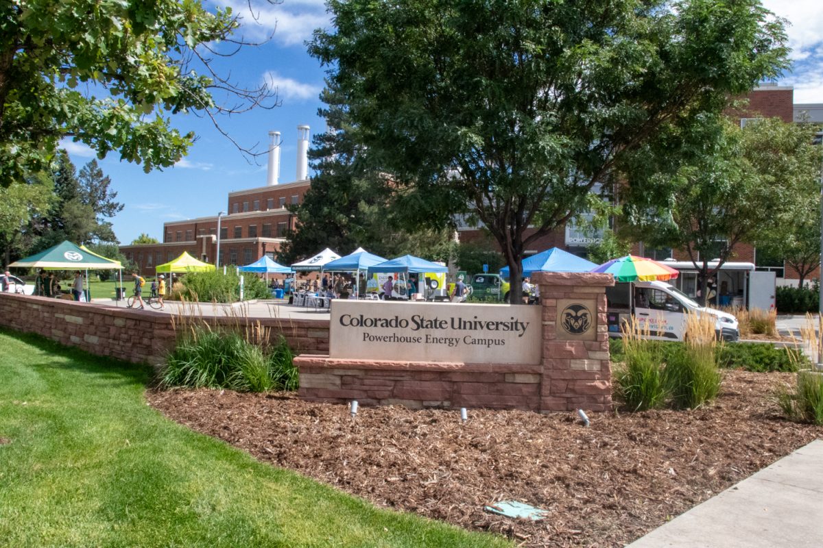 A sign says "Colorado State University Powerhouse Energy Campus" in front of a parking lot with tents in it.