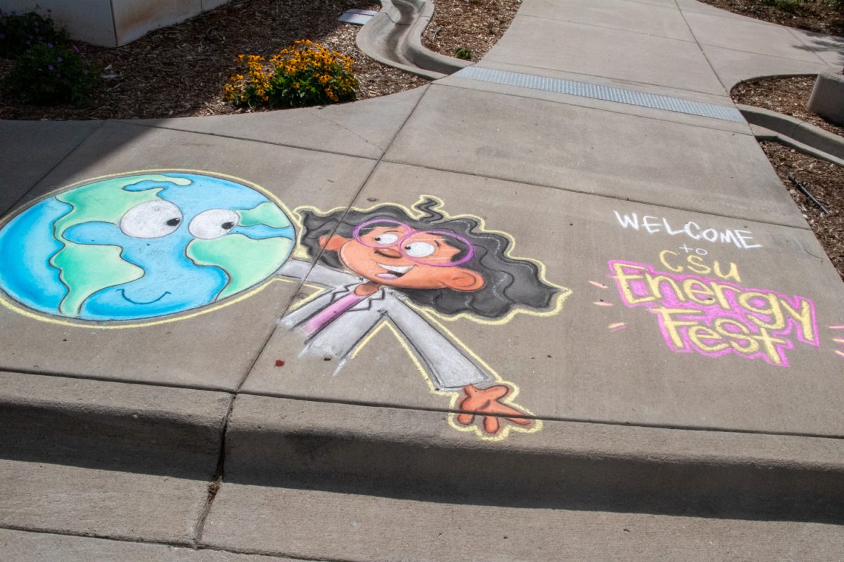 Chalk art featuring the earth with a cartoon face, a girl with a lab coat on, and the words "welcome to CSU Energy Fest" sits on the sidewalk.