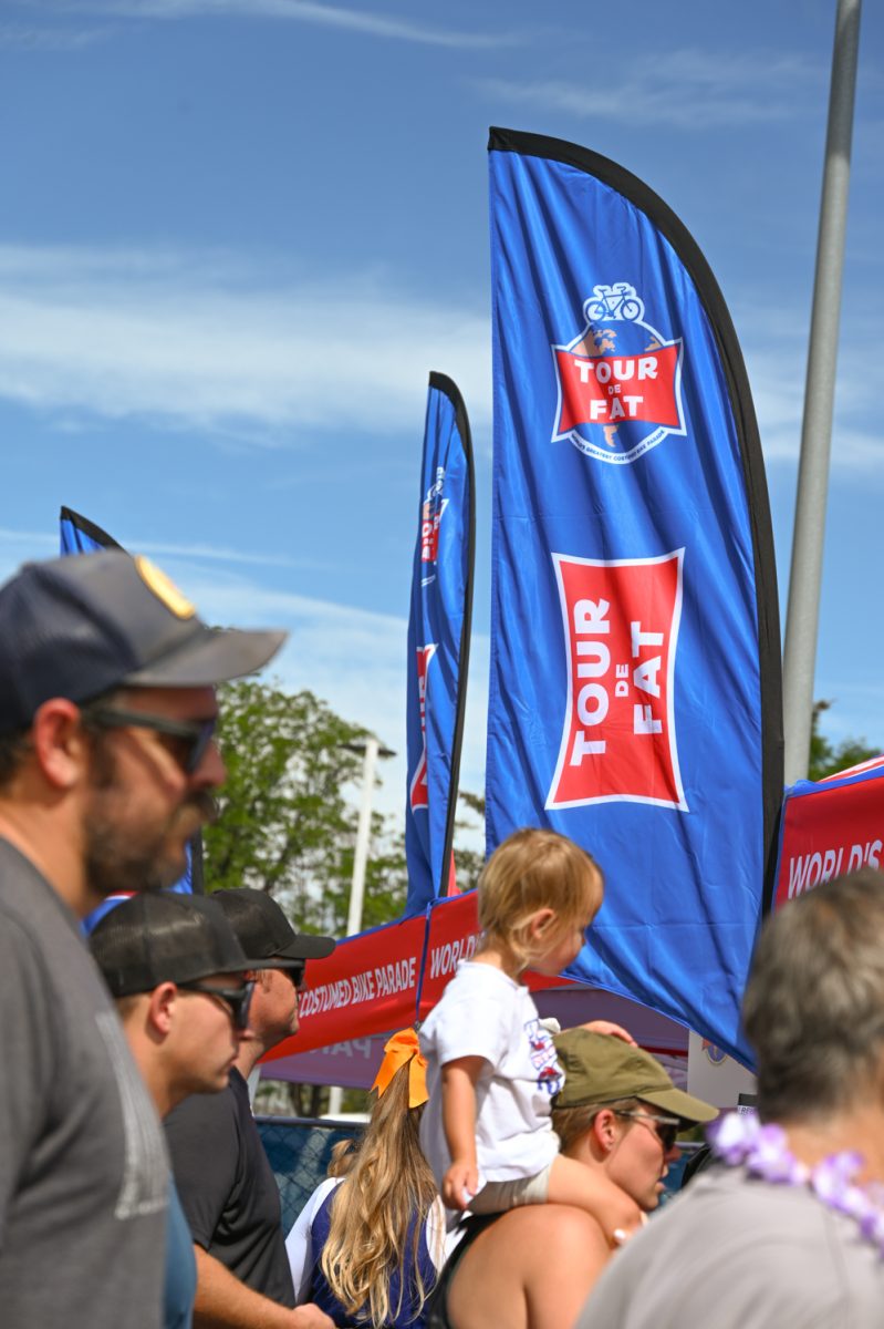 A photo of a Blue banner with red accents that reads "Tour De Fat" outside under a blue sky