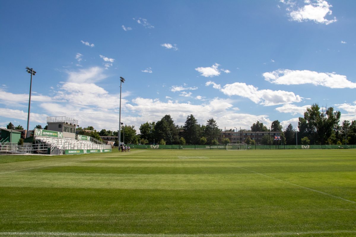 An empty soccer field on a slightly cloudy day.