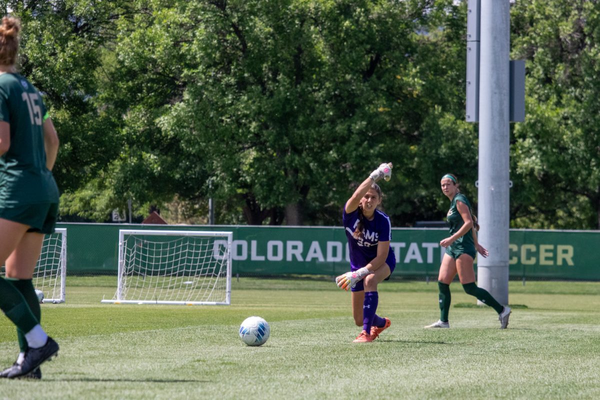 A soccer goaltender rolls the ball to a teammate.