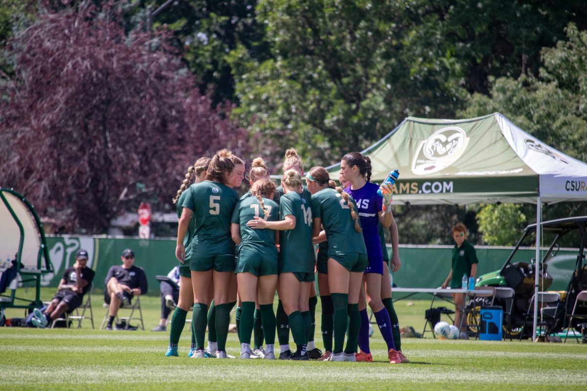 A group of soccer players in a huddle before the match begins