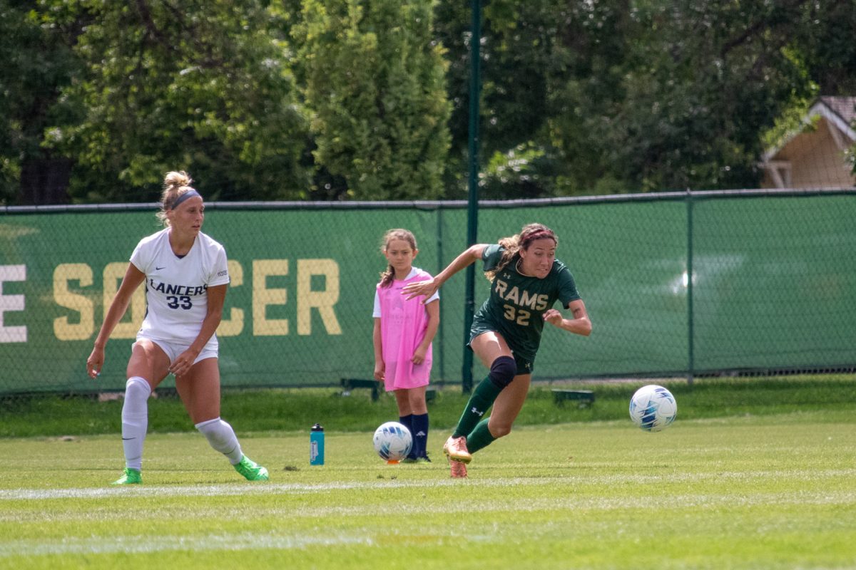 A soccer player chases down a ball.