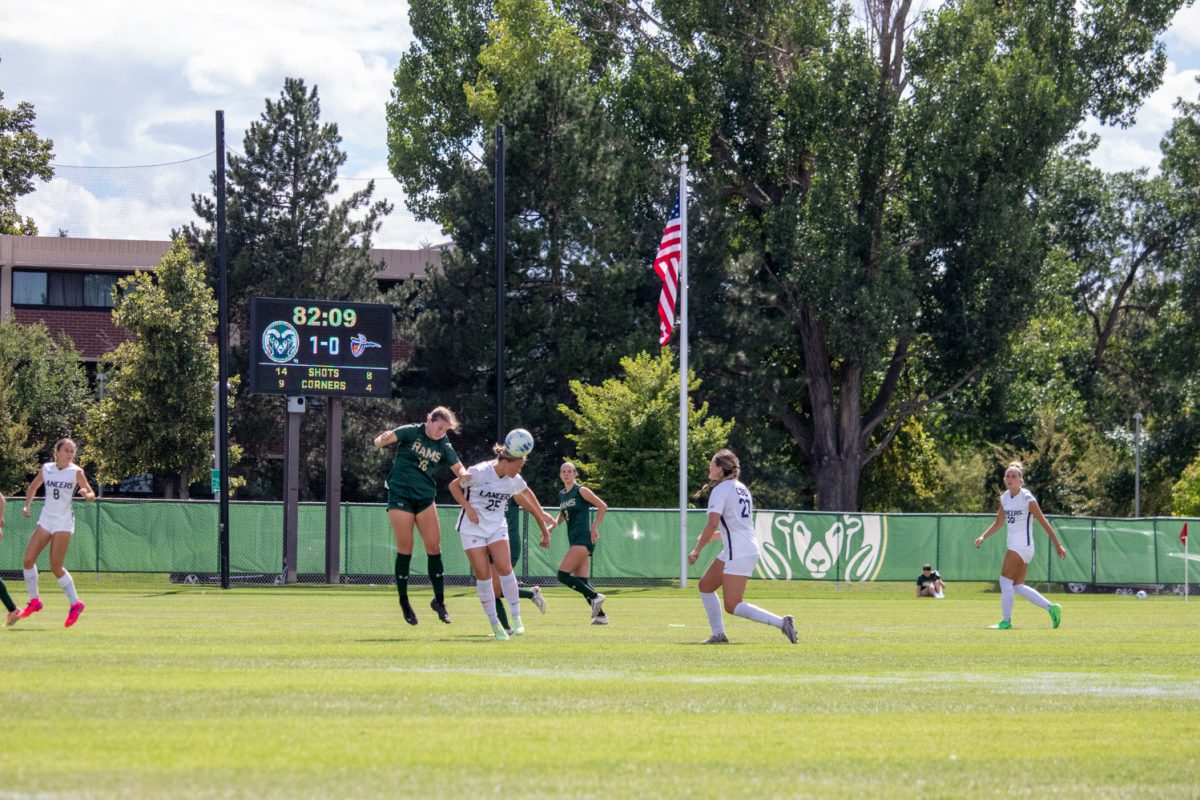 2 soccer players jump to get the ball.