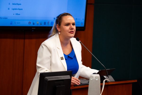 Parliamentarian Madeleine Kamberg stands at a speaking podium.