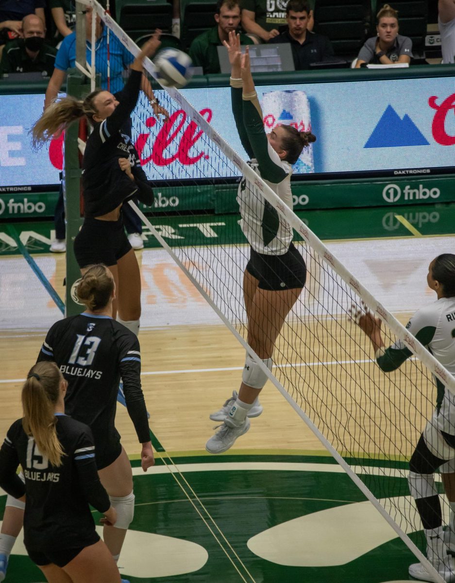 Emery Herman (4) jumps up to block the ball from opponent Creighton University on August 24. 