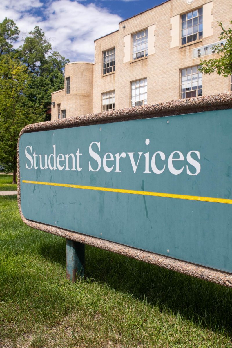 A close up of the Student Services green Colorado State University sign.