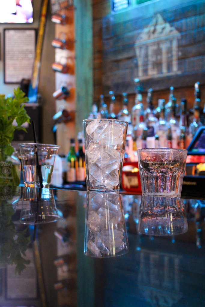Two glasses sit on the bar on a black countertop at Yeti Bar and Grill