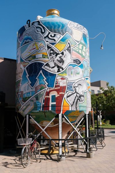 A painted tower with colorful images of Colorado life.