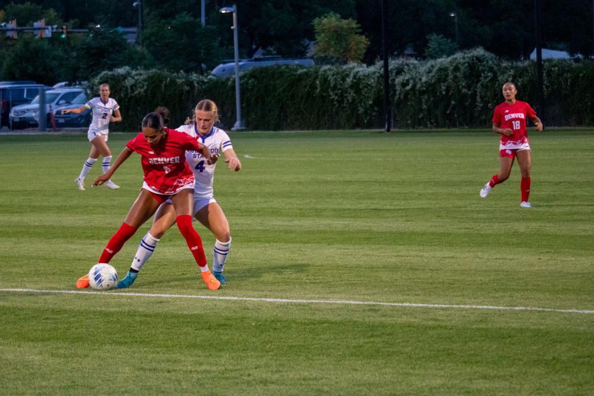 Two soccer players fight over the ball.