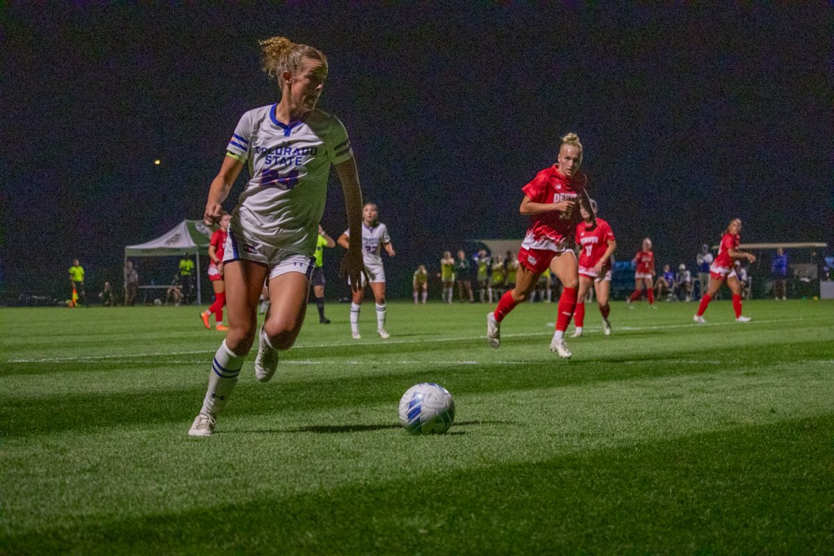 A soccer player is kicking a ball.