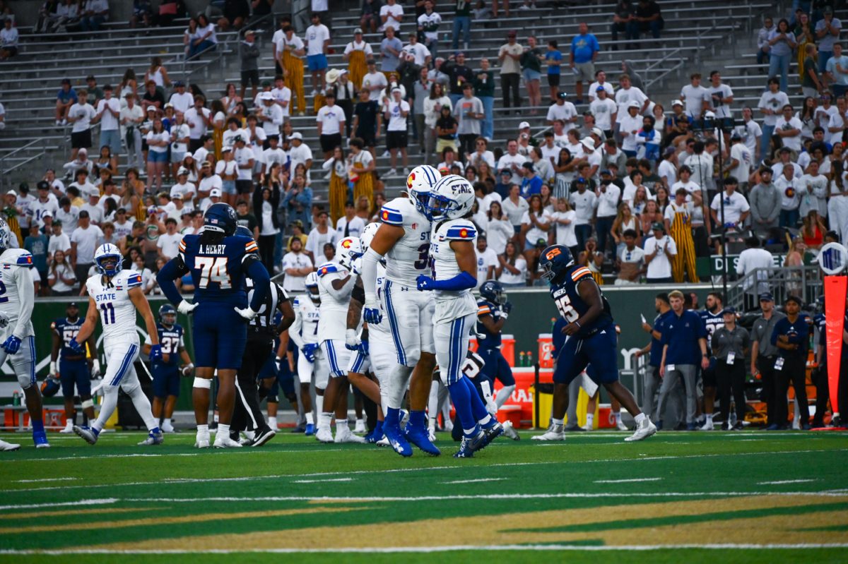 Two players in white and blue chest bump each other