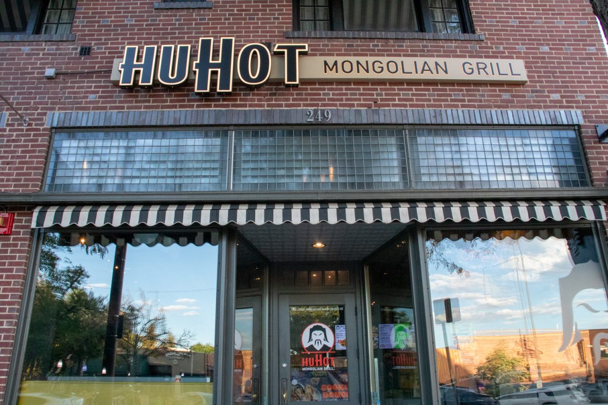 The external of a brick building with windows and a glass door. A sign above the windows reads HuHot Mongolian Grill.