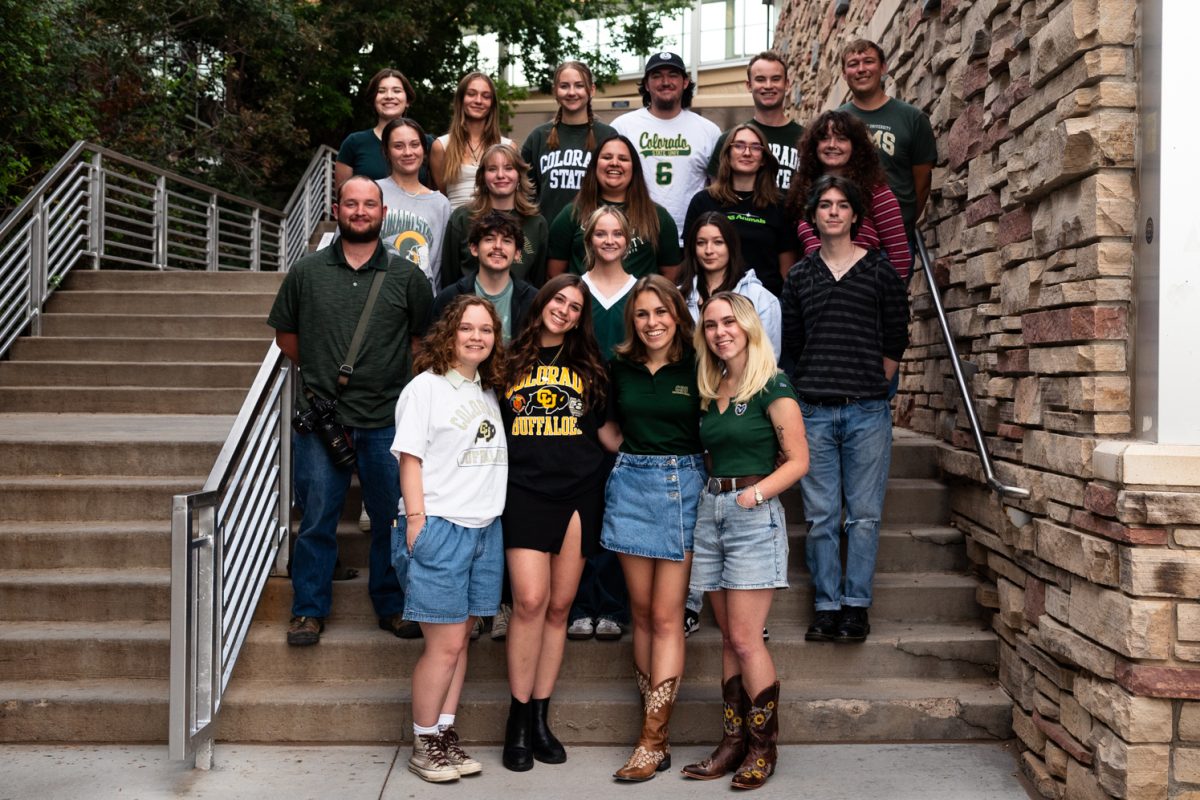 A group of people stand on steps outside.