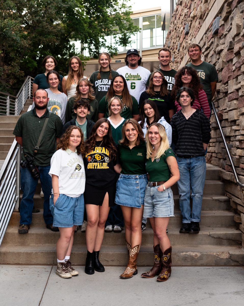 A group of people stand on steps outside.