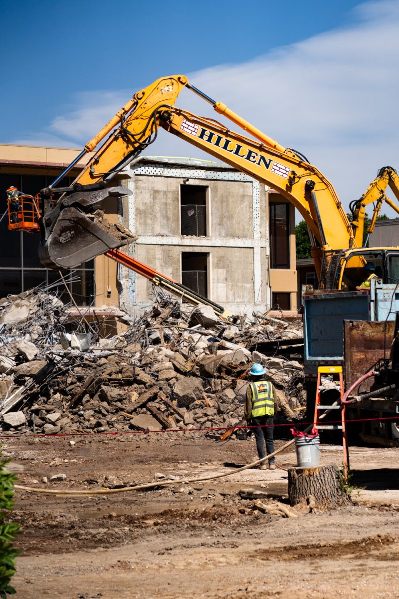 A construction worker watches an excavator remove rubble from a pile during Clark demolition Sept. 12. Demolition of Clark B progresses Sept. 12. The renovations, set to be complete by 2027, have seen the removal of the B wing of Clark. 