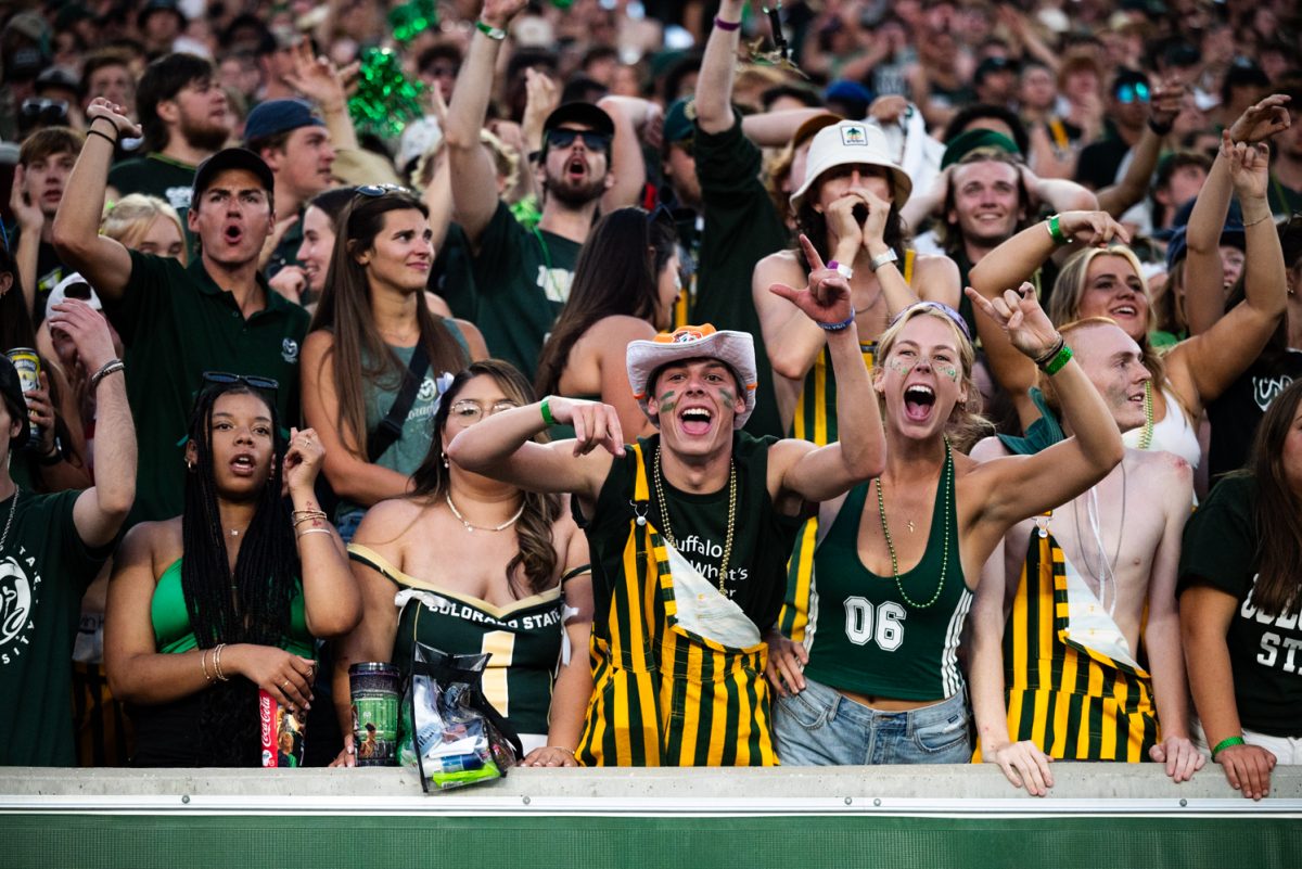 A crowd of cheering students in green and yellow.