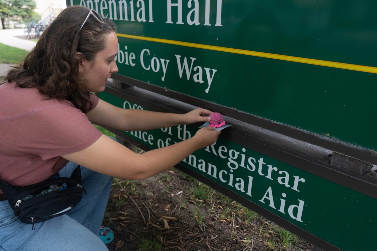 M.M, the Director of Octopi Operations for Octopi of CSU hides an octopi on the sign for Centennial Hall on the Oval Sept. 17. M.M and the rest of the group are anonymous to preserve the integrity and mystery of the group, which focuses on random acts of kindness around campus. 