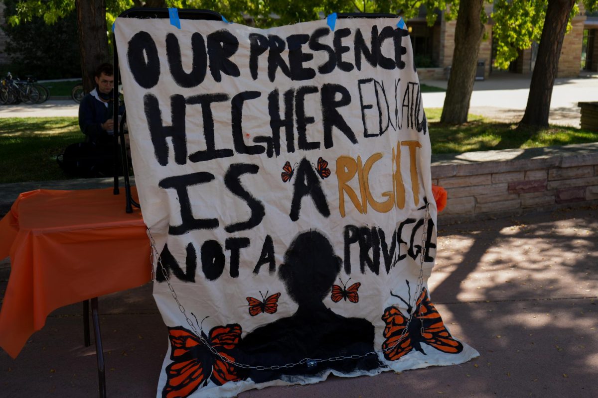 A banner reading "Our presence in higher education is a right, not a privilege" is placed at a table at the Wellness Wonderland event hosted by the Associated Students of Colorado State University on Sept. 20. The banner, which had previously been removed from The Plaza on Sept. 11, is an anonymous form of protest from undocumented students at CSU. 