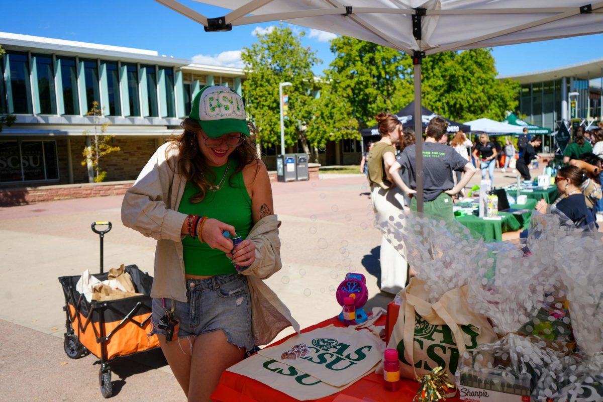 Associated Students of Colorado State University Director of Basic Needs Jorja Whyte organizes a table of raffle prizes during Wellness Wonderland. The event, held on Sept. 20 on The Plaza, was hosted by ASCSU's Department of Basic Needs. 