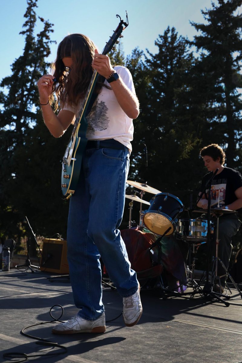 Josh Kates play guitar for local band, Heliotrope, during annual Battle of the Bands competition on Sept. 19. 