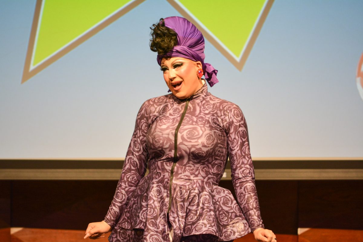 Performer in a purple bodysuit and purple headpiece