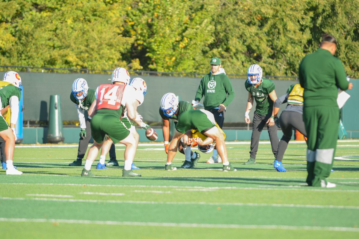 CSU football players running a play during practice. 