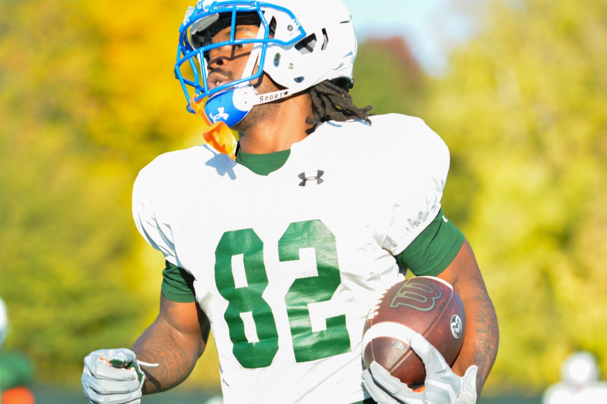 A CSU football player running with the ball during morning practice. 