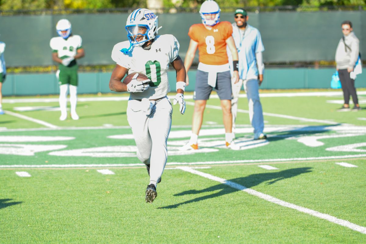 CSU football player running a play during morning practice. 