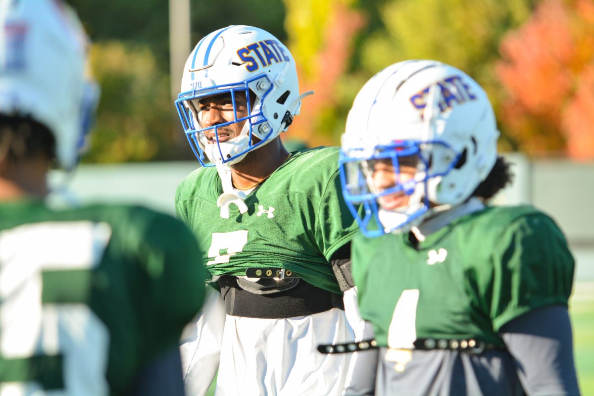 Three CSU football players waiting for their turn to run a play during morning practice. 