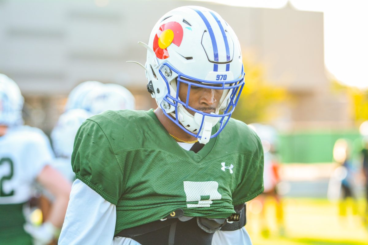 CSU football player looking down while waiting for his turn to run a drill. 