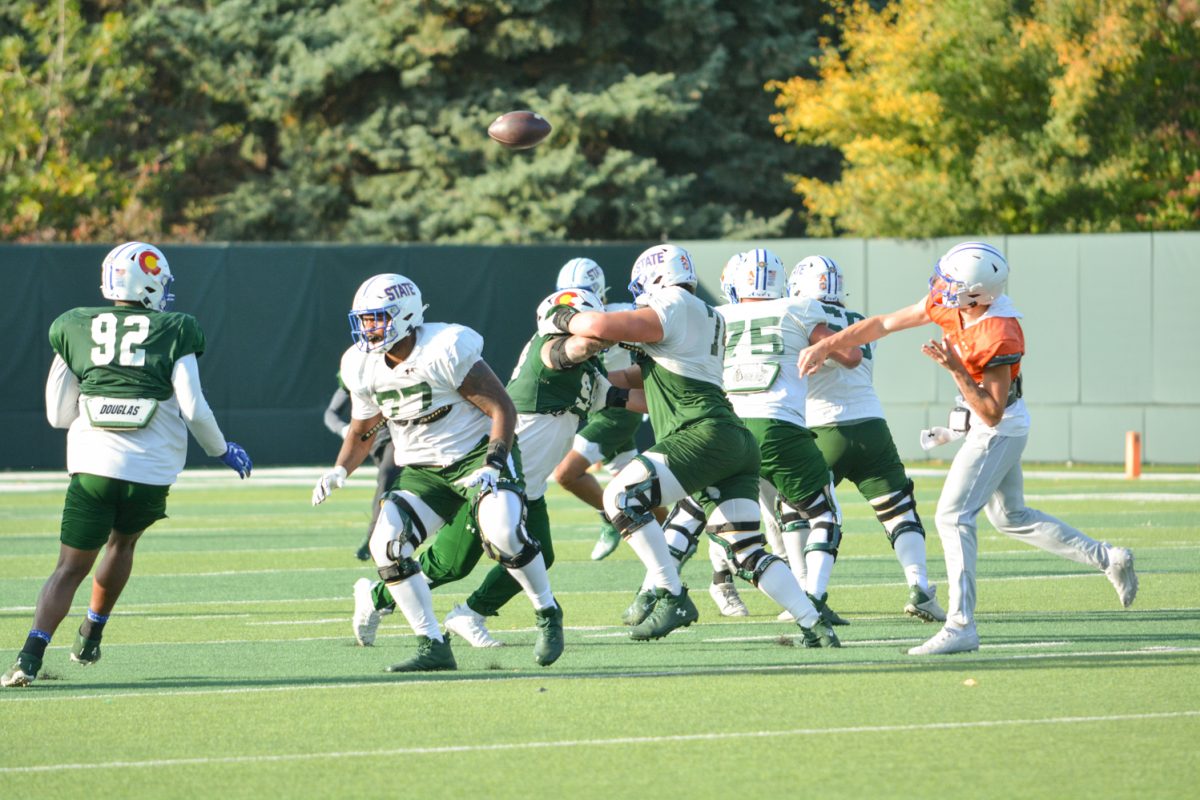 CSU football players running a play during morning practice. 