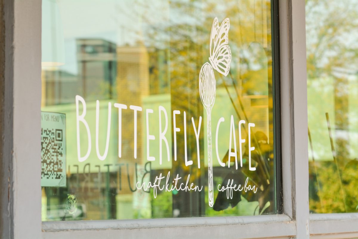 The words "Butterfly Cafe" written on a window