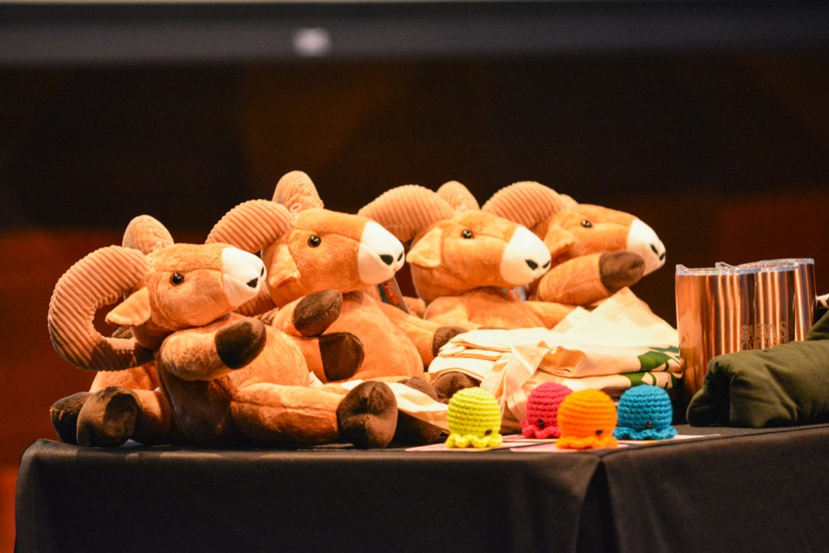 Toy rams, octopuses, mugs and shirts on a table