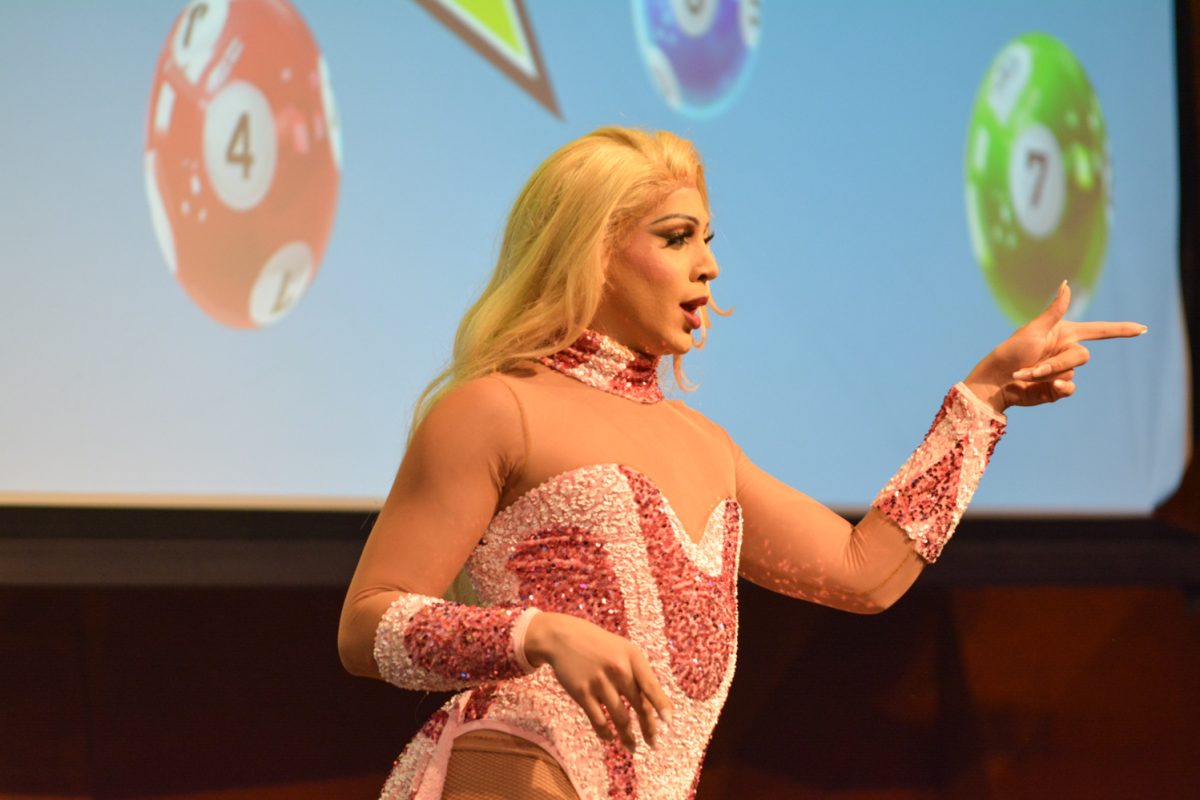Performer in a pink bodysuit pointing at the crowd