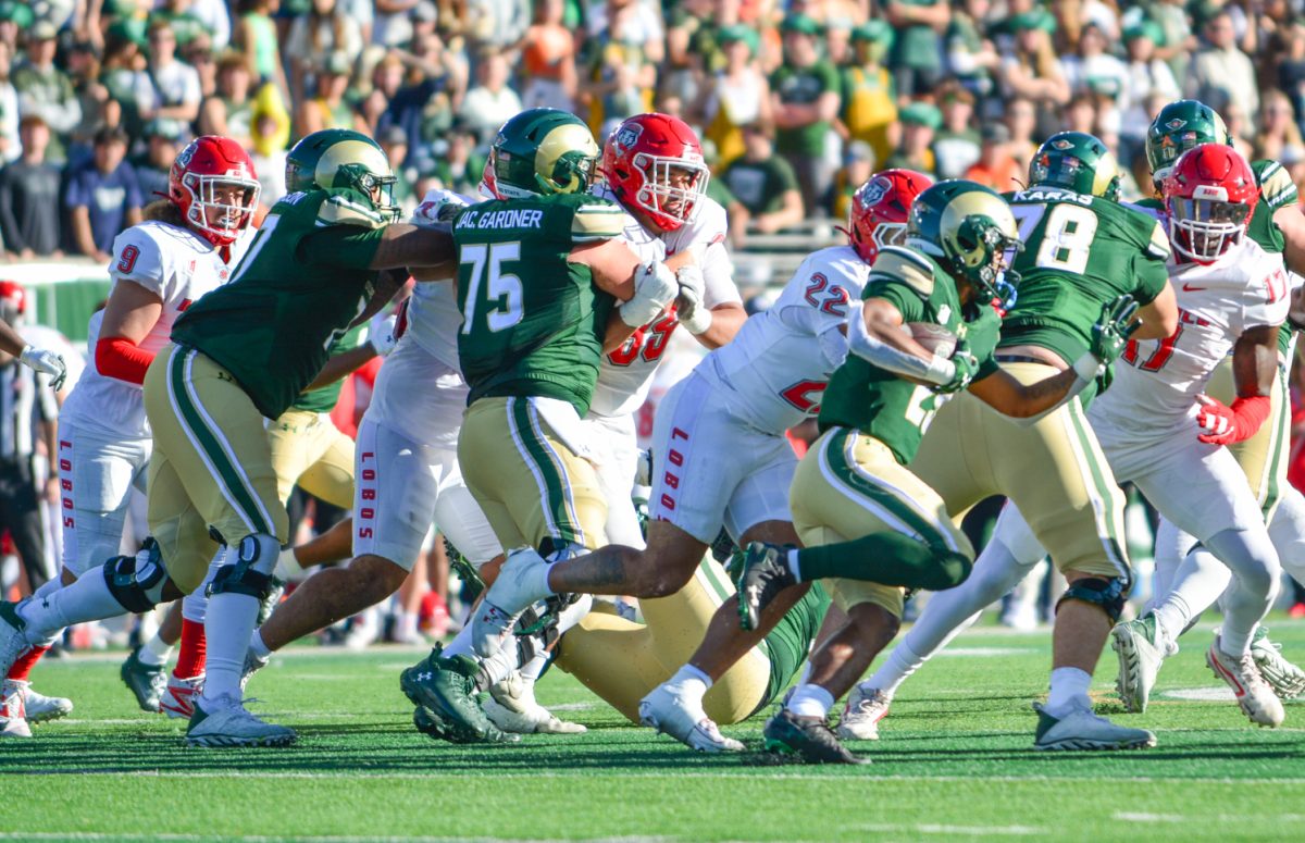 Players in green and gold jerseys pushing players in white and red jerseys.