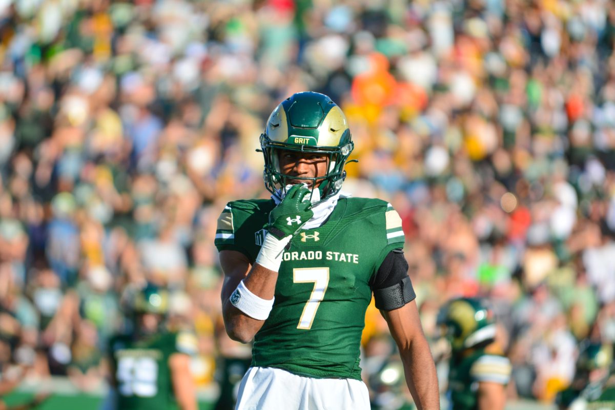 Football player in green jersey walking towards the camera