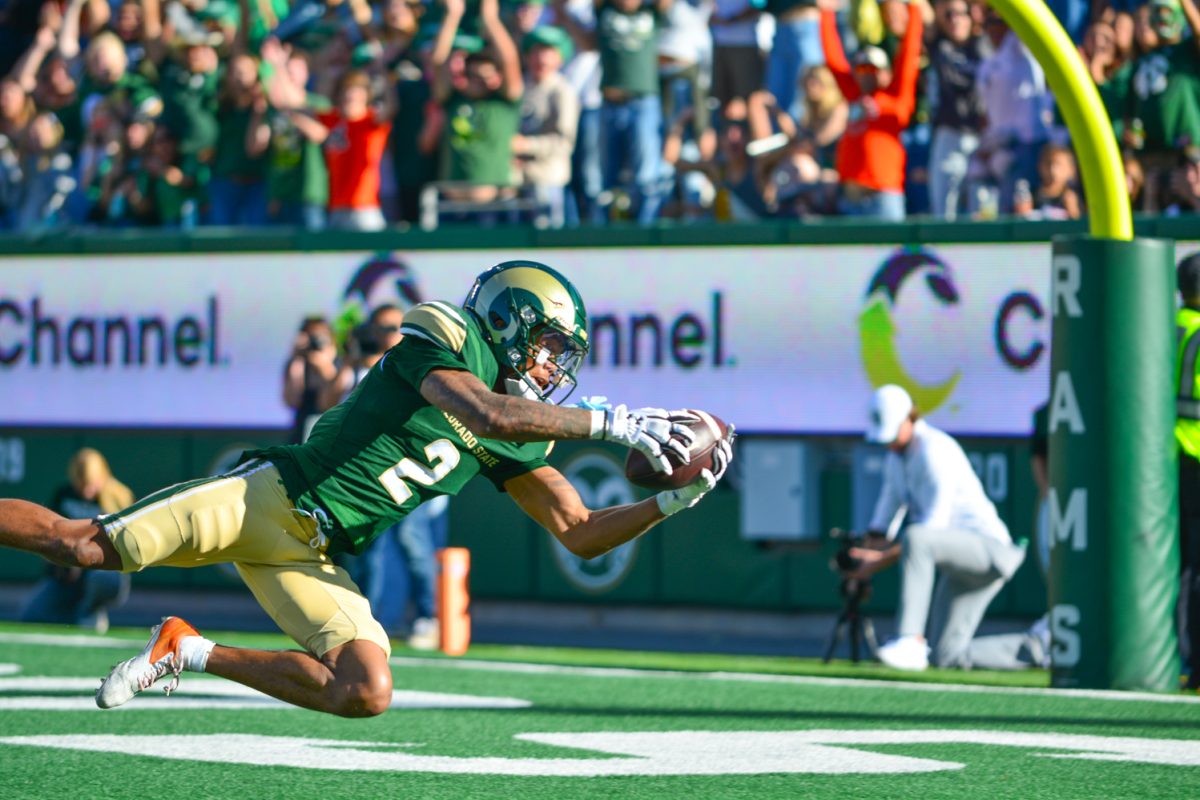 Football player in green jersey falling to the ground