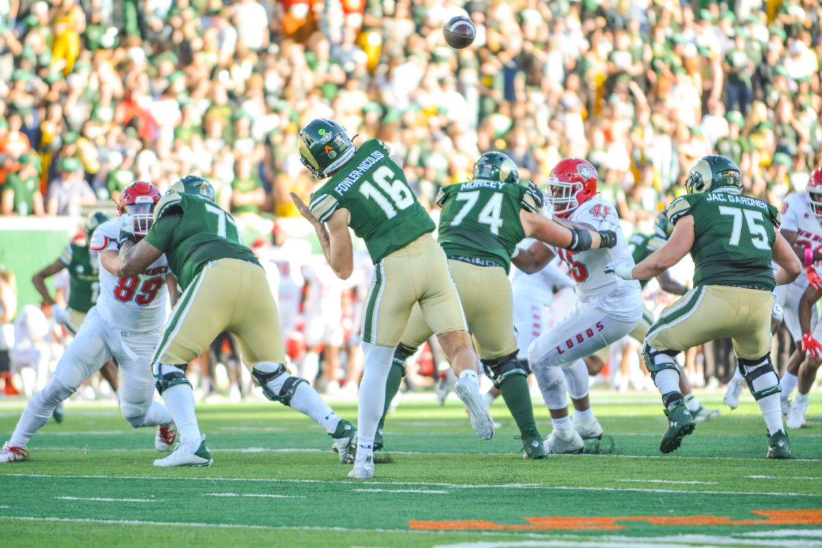 A football player in green jersey throwing a ball