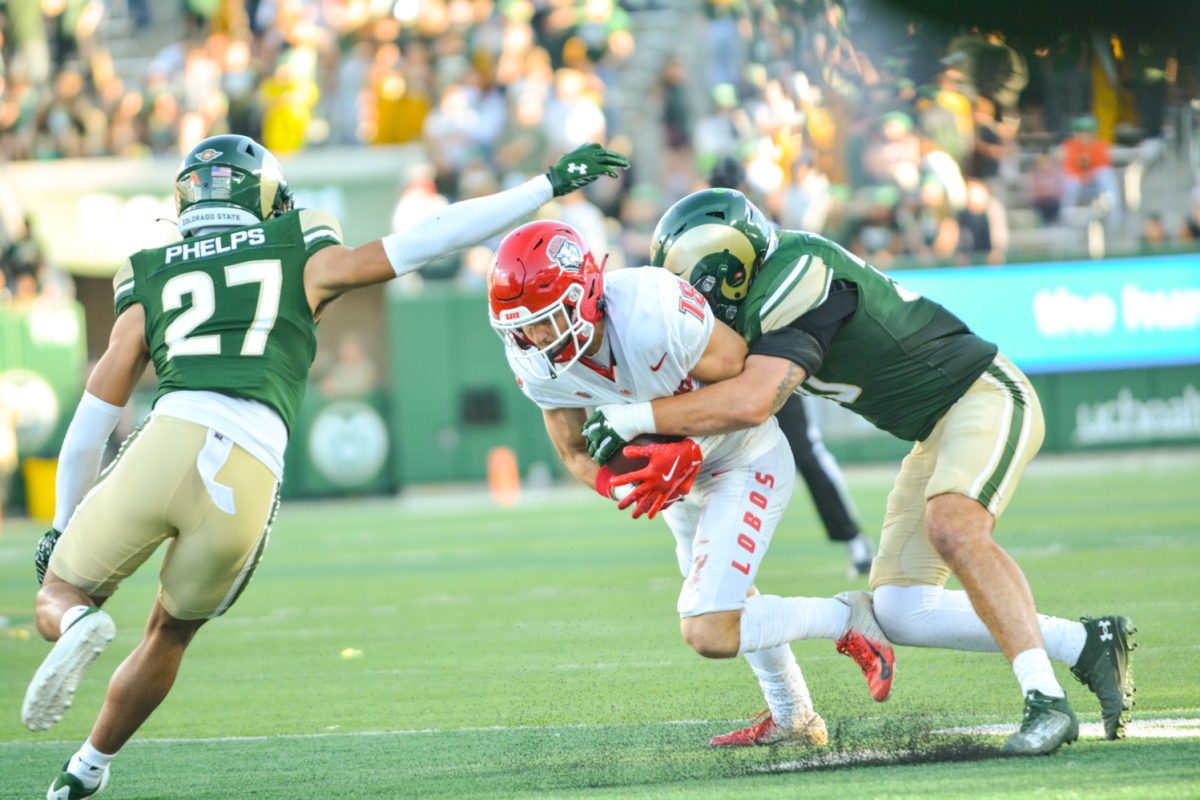 A player in green jersey tackling a player in a white jersey