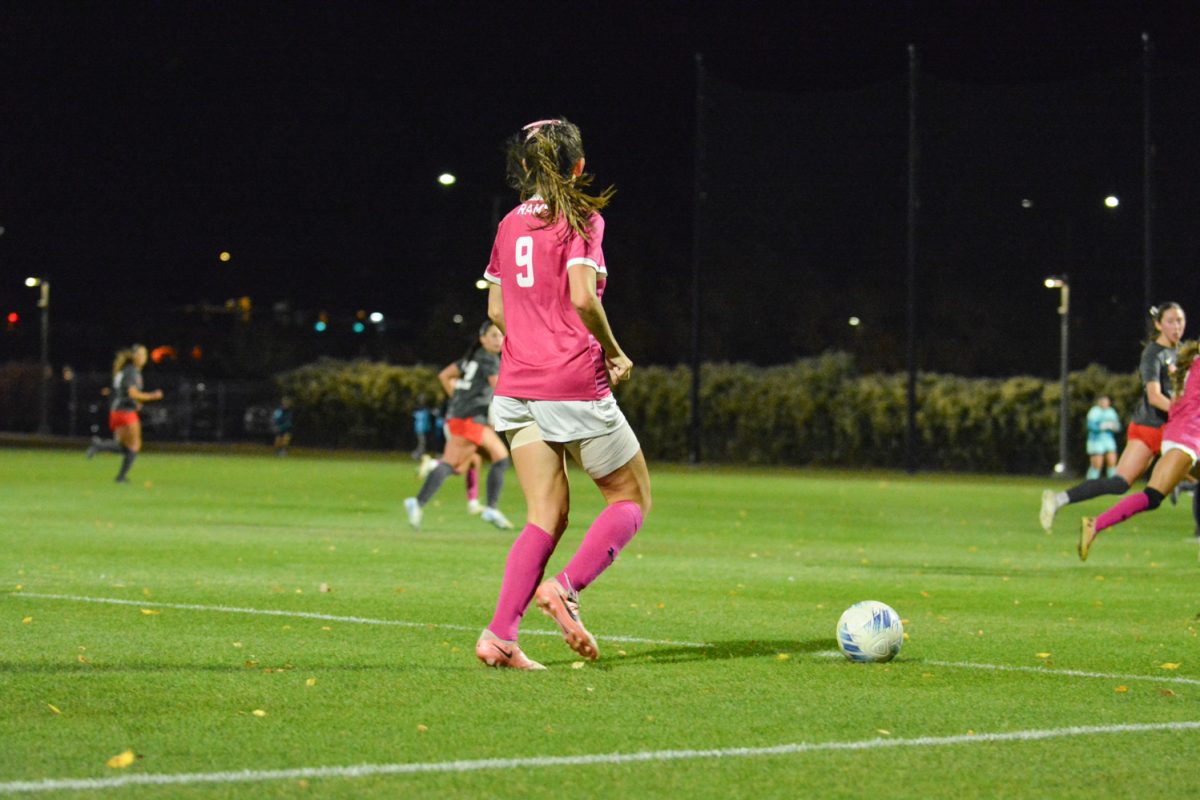 girl in pink jersey running with ball
