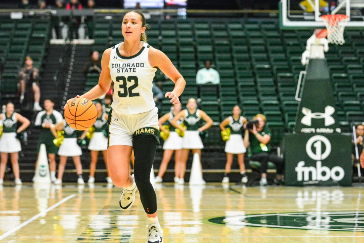 Girl in green and white jersey dribbling a ball