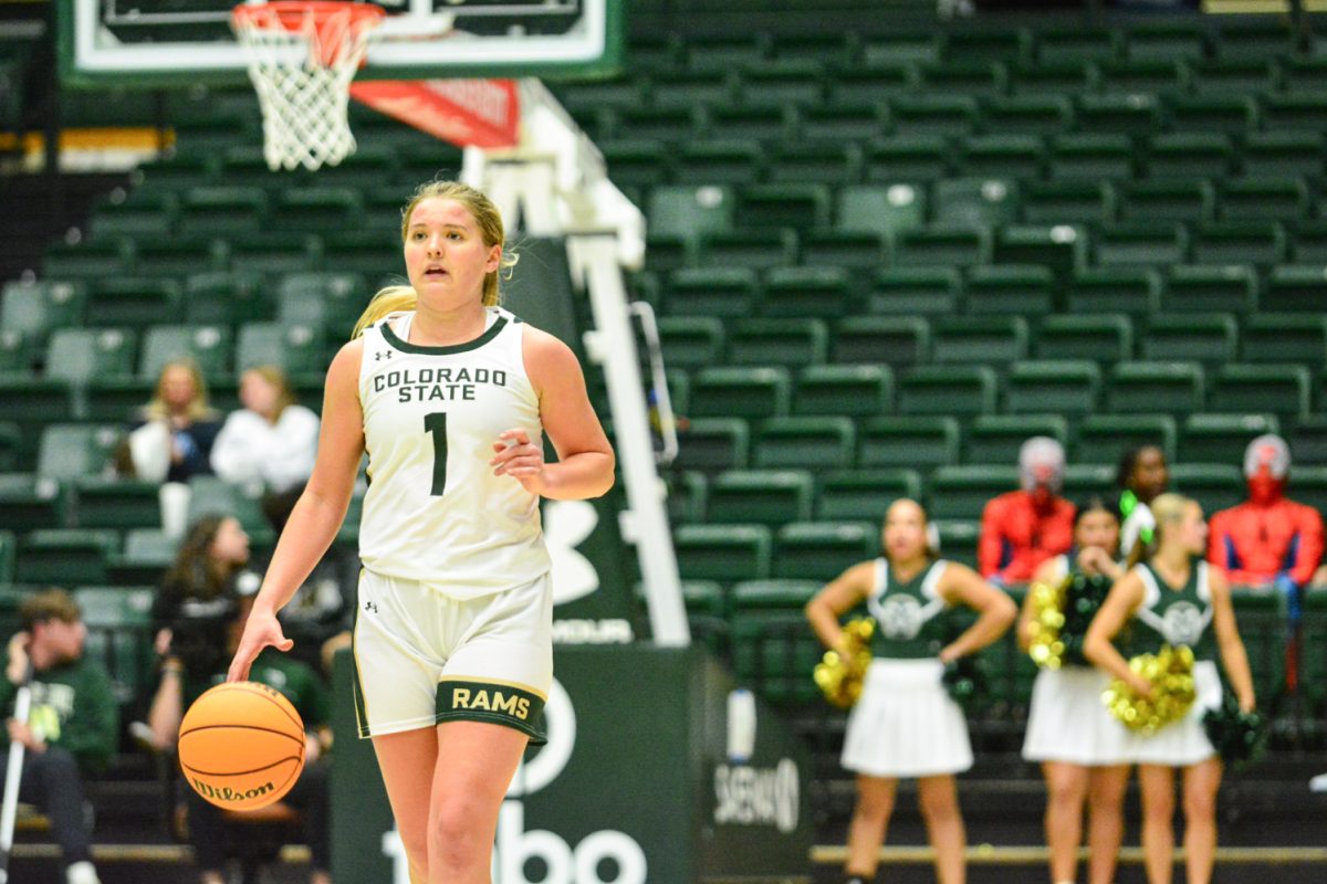 Girl in green and white jersey dribbling the ball