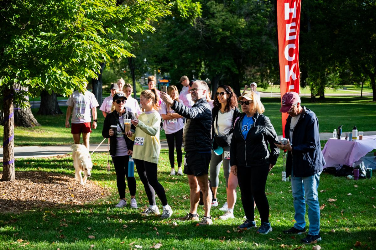 A group of people in a grassy green area with trees.