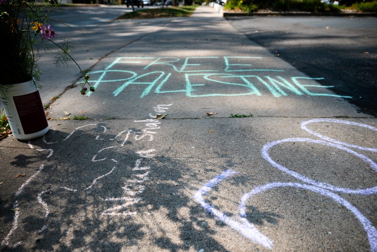 Green chalk on a sidewalk reading "Free Palestine."