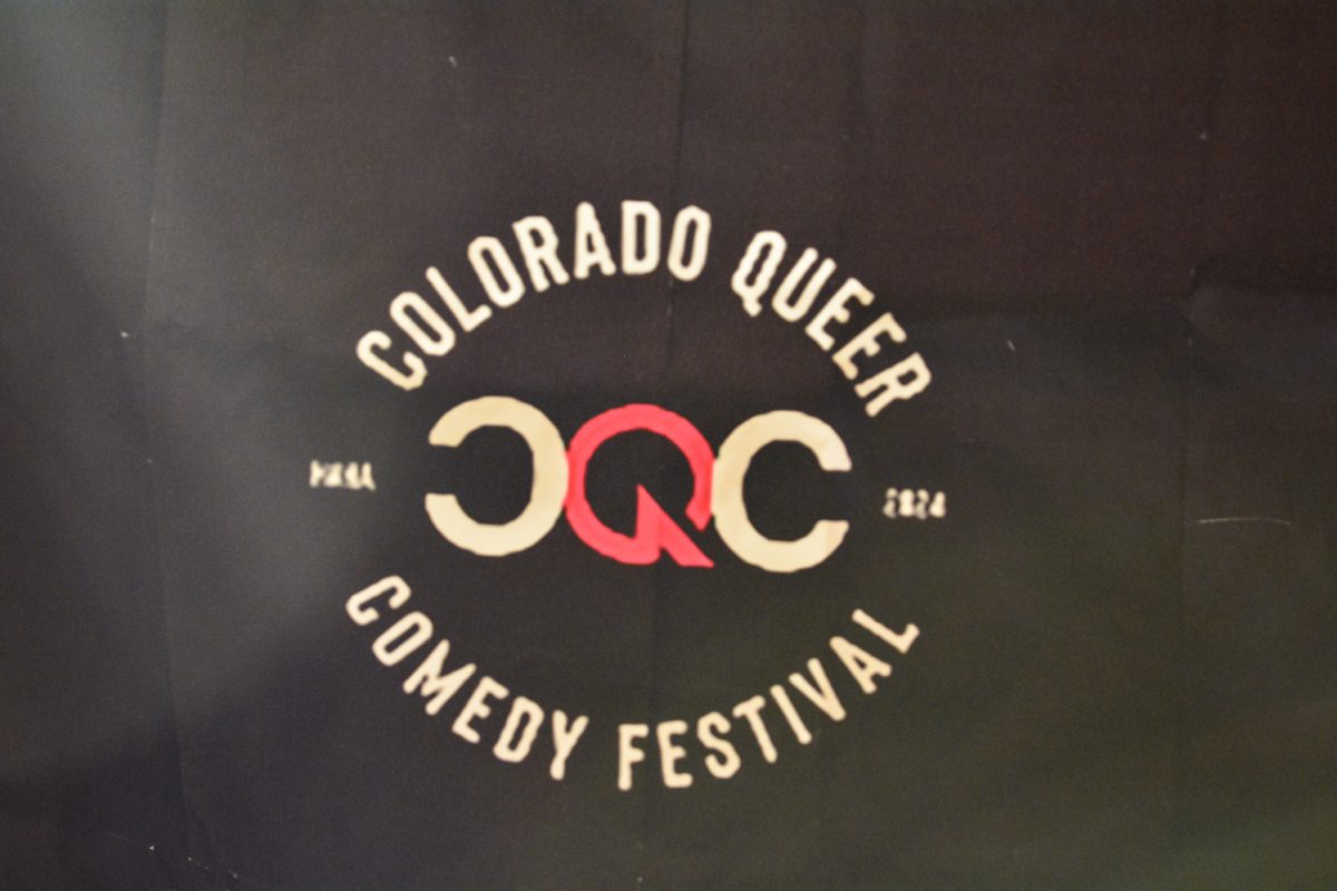 A Colorado Queer Comedy Festival symbol on a black backdrop