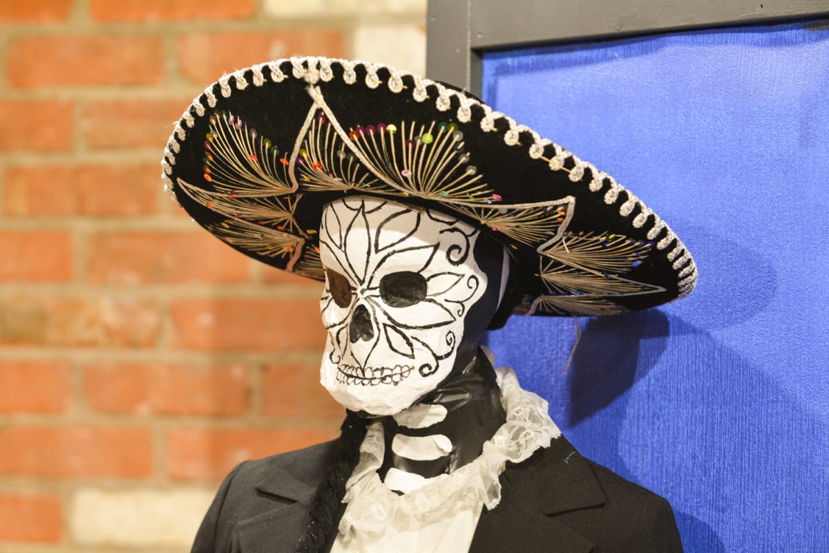 A mannequin dressed in a decorative sombrero and painted to look like a skeleton.
