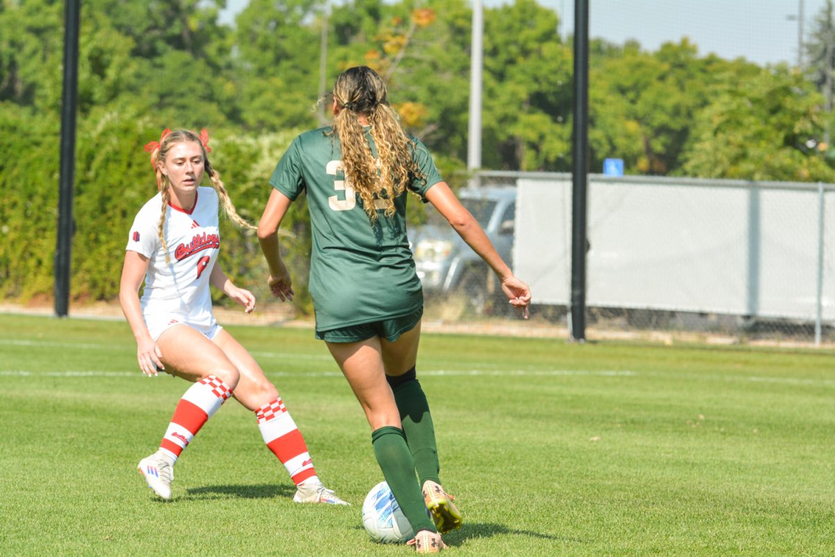 Two soccer players fighting over a soccer ball
